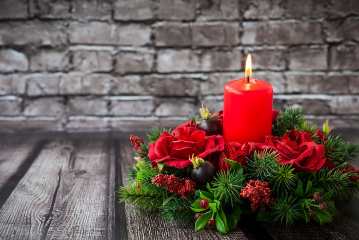 Christmas candle arrangement with red roses and pine branches