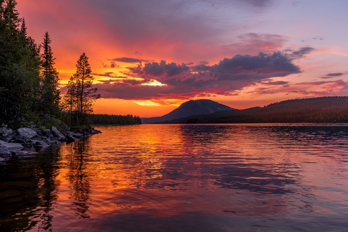 Sunset over a mountain lake with trees