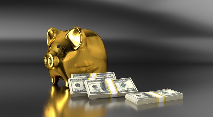 Golden Piggy Bank with Stacks of US Dollars