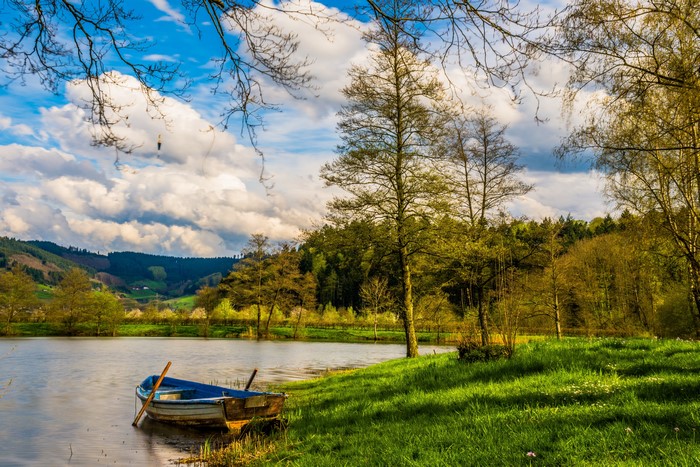 Boat on a lake with rolling hills and trees