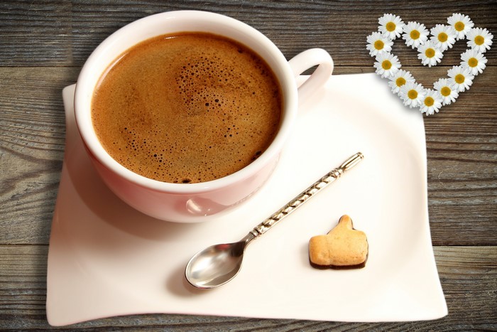 Coffee cup with heart made of daisies and a thumb up cookie