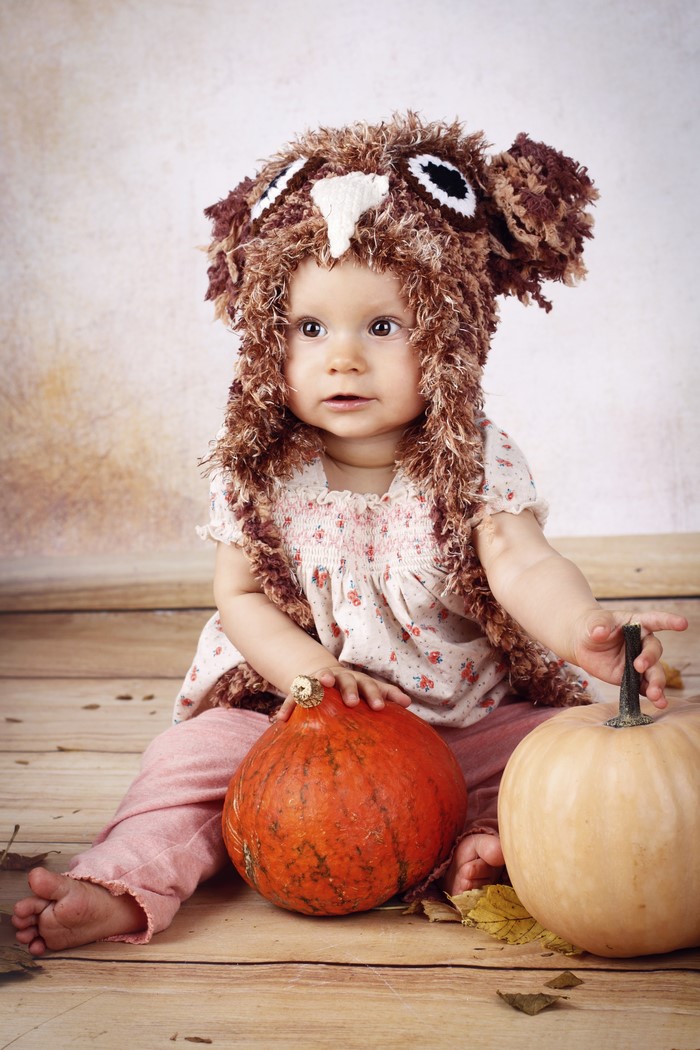Baby in owl hat with pumpkins