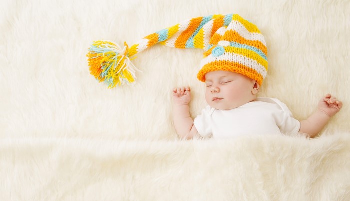 Baby sleeping in a colorful winter hat