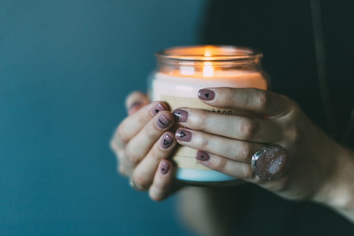 Hands holding a lit candle