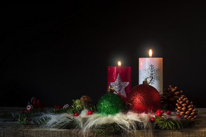 Christmas candles with ornaments and pine cones