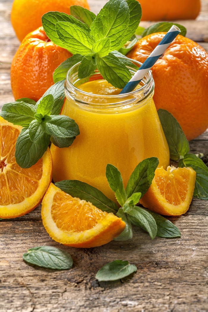 Orange juice in a jar with oranges and mint