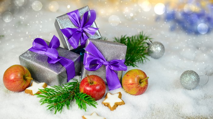Christmas gifts with apples and cookies in snow