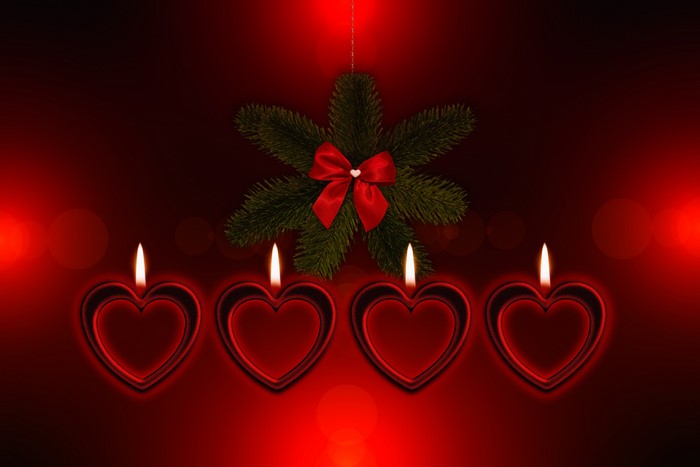 Four heart-shaped candles and a Christmas ornament