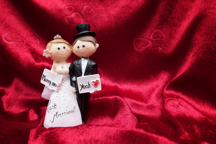 Wedding cake toppers with "Marry me" and "Yeah" signs