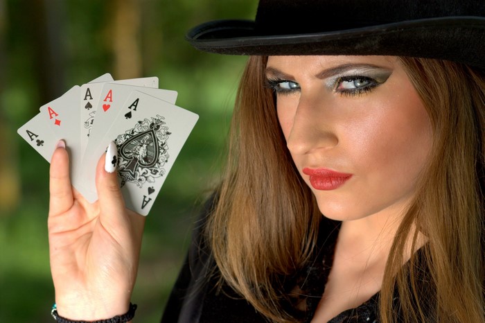 Woman in Hat Holding Four Aces
