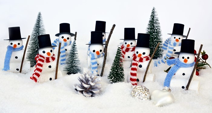 Christmas snowmen with hats and scarves in the snow