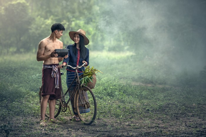 Couple with bicycle and radio in foggy forest