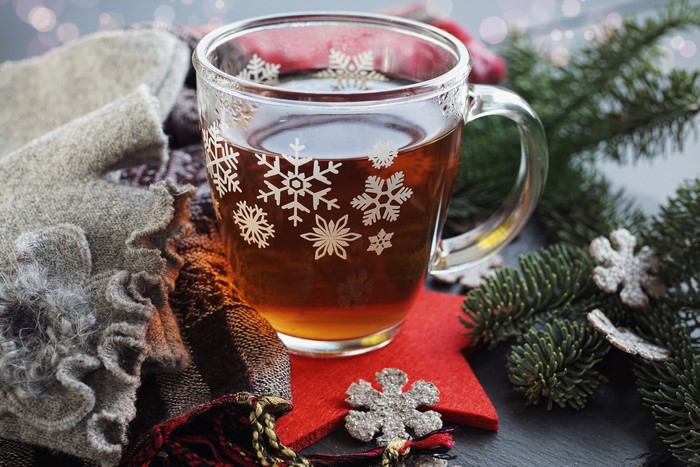 Christmas tea in a snowflake mug with pine branches