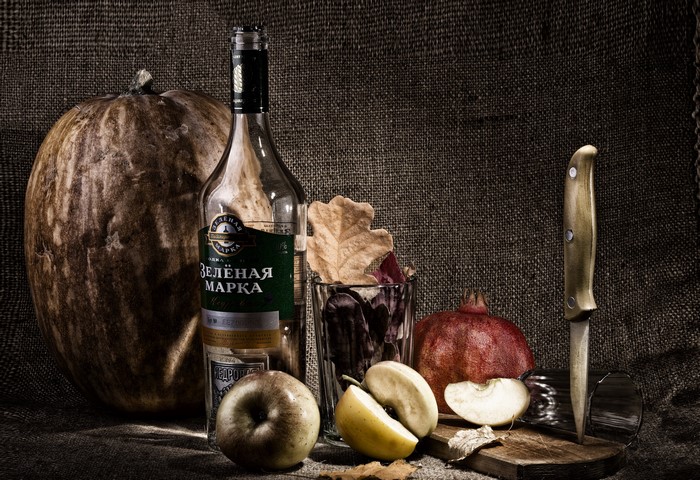 Still life with pumpkin, apples, vodka, and pomegranate
