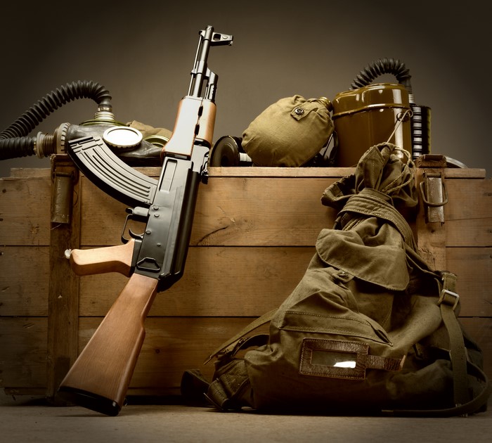 Assault rifle AK on a wooden crate with military gear