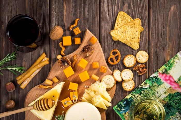 Cheese and Snacks on a Wooden Board with Wine