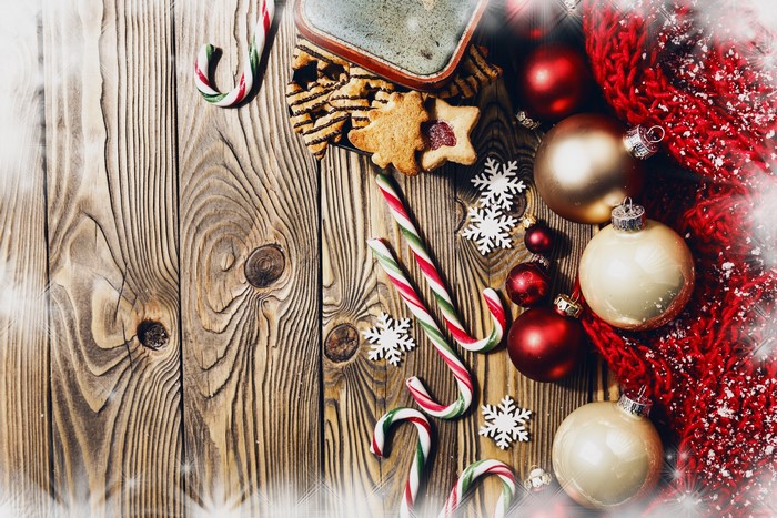 Christmas ornaments, candy canes, and cookies on wood
