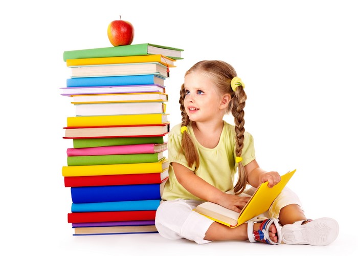 Little girl with stack of books and apple