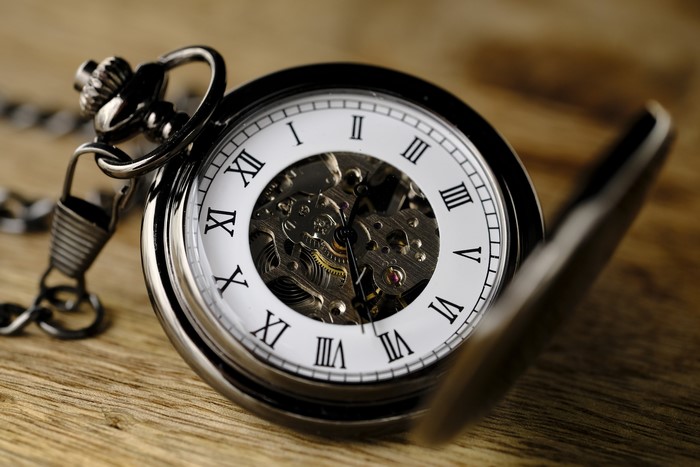 Pocket watch with Roman numerals and visible gears