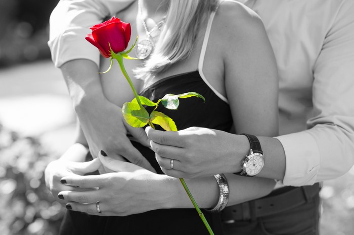 Couple hugging with a red rose