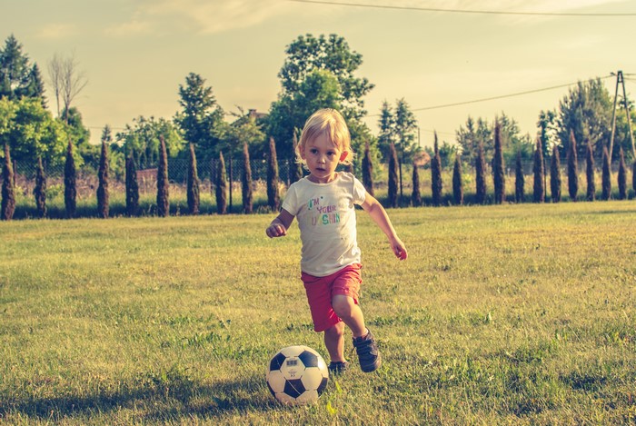 Young boy playing soccer on a grassy field