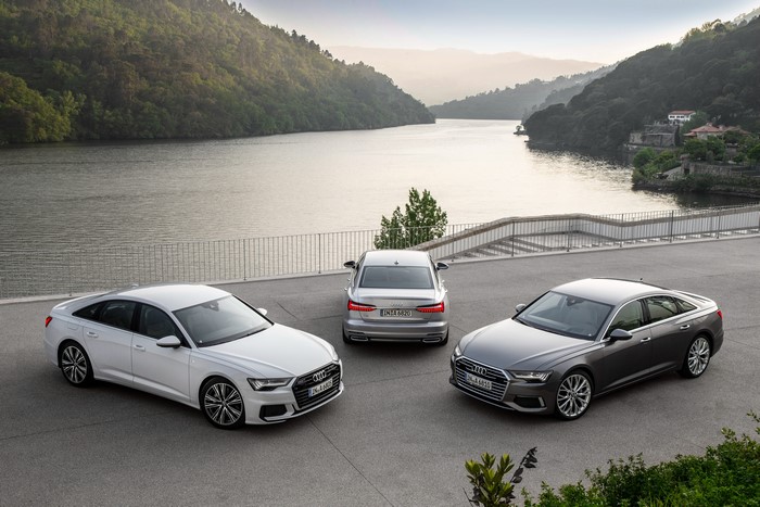 Three Audi A6 cars by a lake