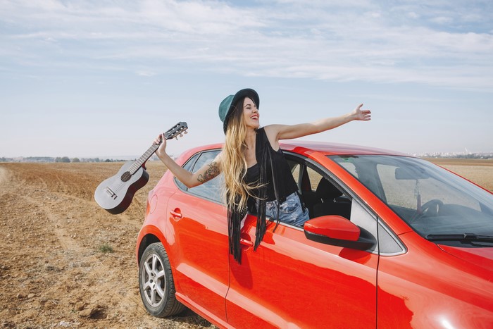Blonde girl with guitar in a red car