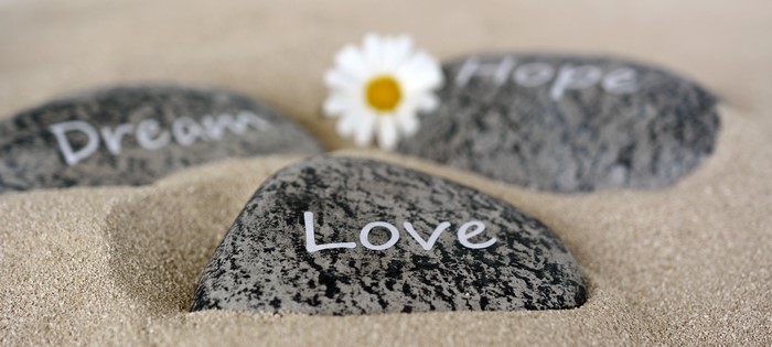 Stones with words Love, Dream, Hope on sand