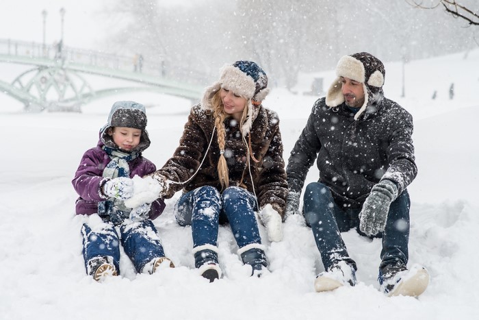 Family sitting in the snow during winter