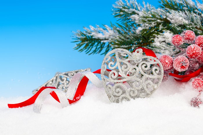 Christmas ornaments with pine branches and berries in snow