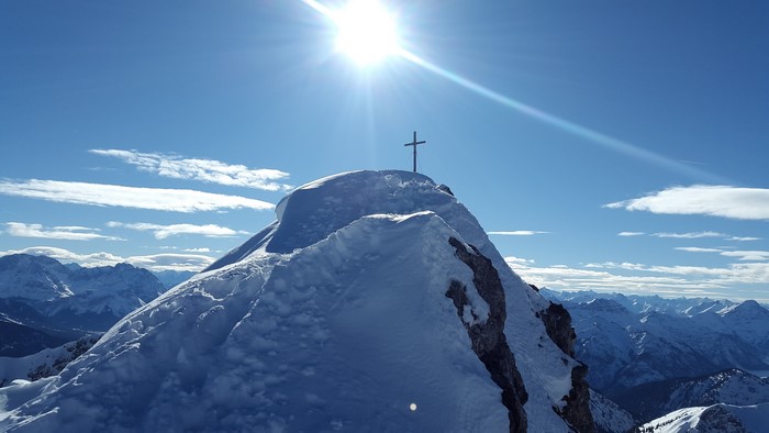Snowy Mountain Peak with Cross and Sun