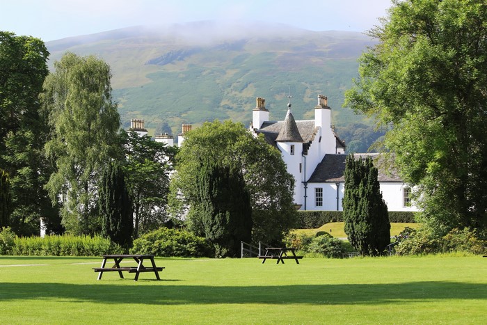 White castle with picnic tables on a lawn in Scotland