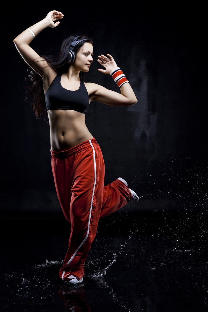 Woman with headphones dancing in red pants
