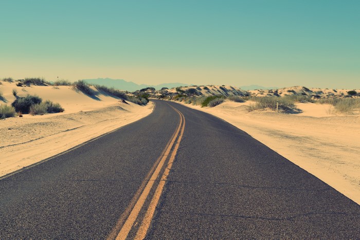 Asphalt Road Through Desert Dunes