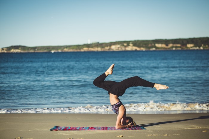 Woman doing yoga on the beach