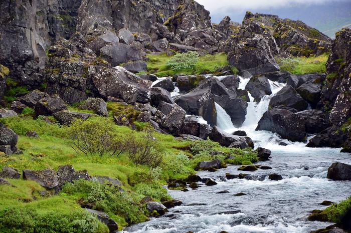 Rocky stream with waterfalls and green grass