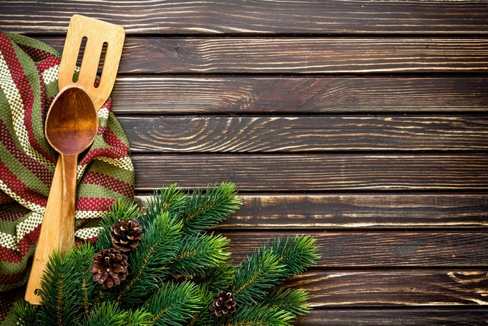 Christmas pine branches with wooden spoon and towel on wood planks