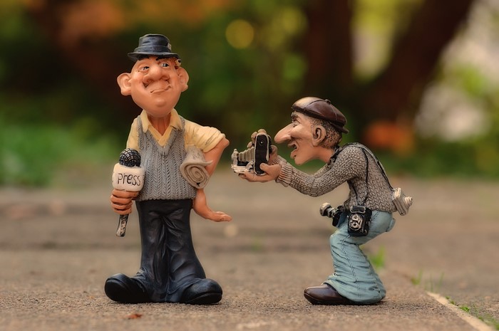 Two cartoon figures, a reporter and a photographer