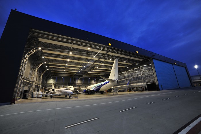 Airplanes in a hangar at dusk