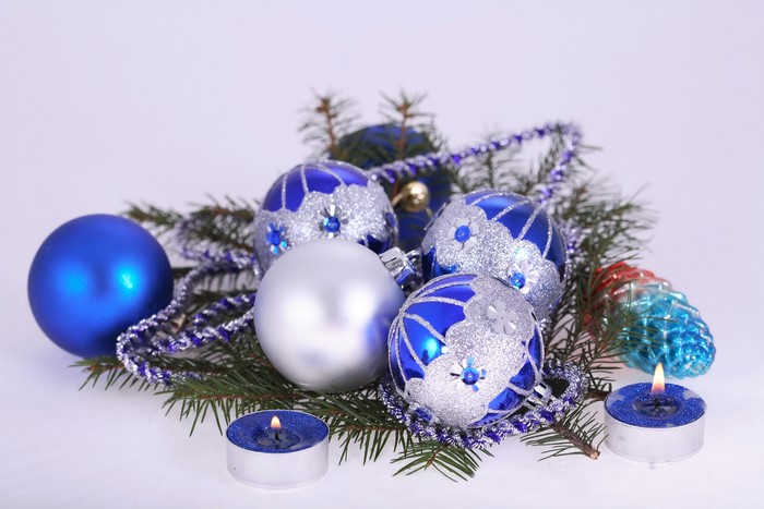 Christmas ornaments and lit candles on pine branches