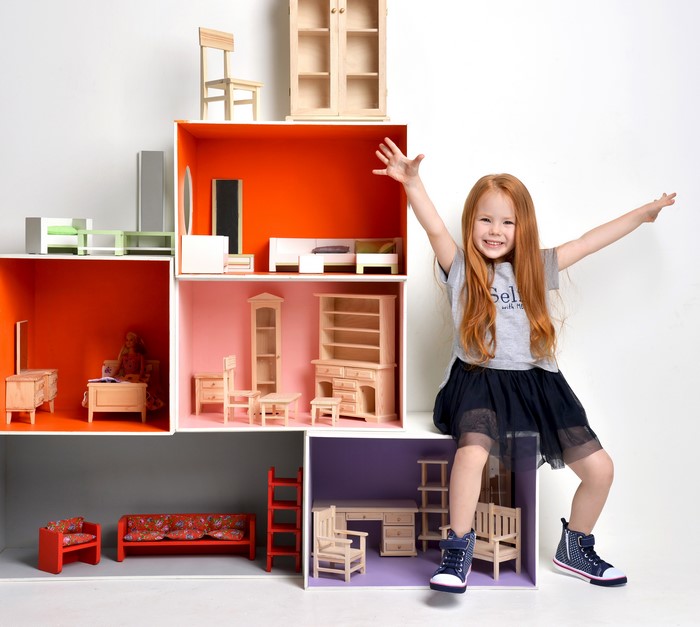Little girl playing with dollhouse furniture