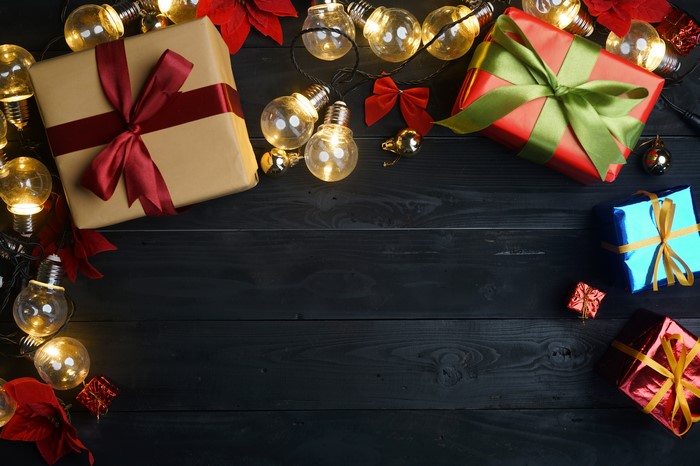 Christmas gifts and fairy lights on wood planks