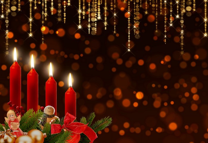 Four red candles with Christmas decorations and bokeh lights