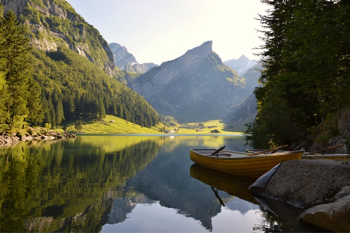 Yellow boats on a lake with mountains and forests