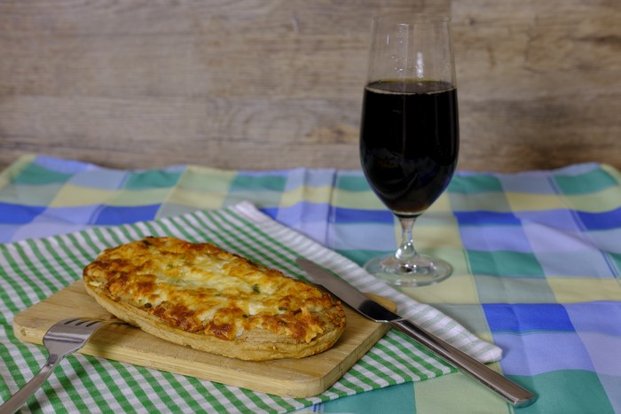 Savory pie with cheese and a dark beverage
