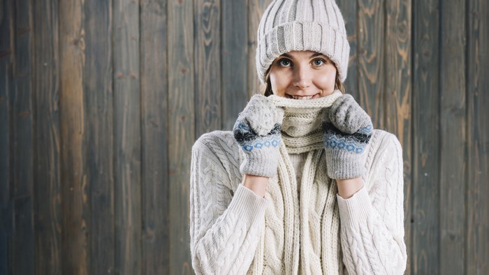 Woman in winter hat, scarf, and mittens smiling