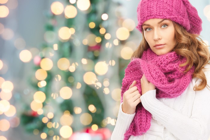 Woman in pink scarf and hat with Christmas lights