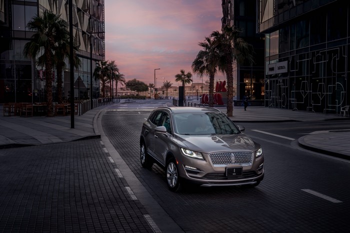 2018 Lincoln MKC driving on a city street at dusk