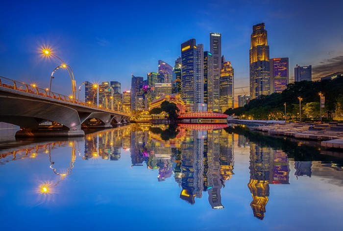 Singapore skyline with bridge and river reflection at dusk