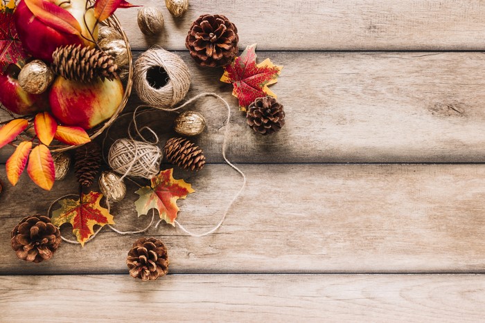 Autumn harvest arrangement with apples, pine cones, and twine